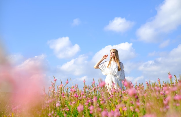 Frau im weißen Kleid auf blühendem Esparsettenfeld Frau auf einem blühenden rosa Feld