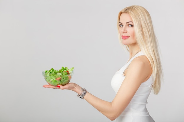 Frau im weißen Kleid mit frischem Salat