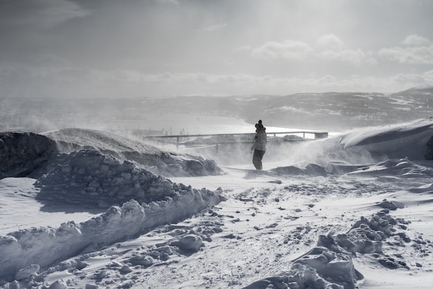 Frau im Winteranzug vor dem Hintergrund eines schneebedeckten Feldes