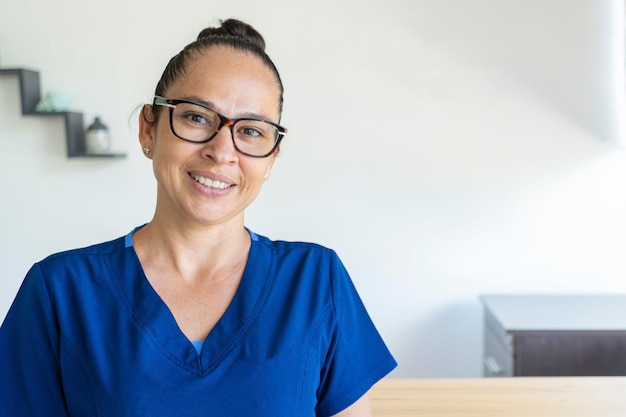 Frau in Brille trägt eine blaue Uniform schaut lächelnd in die Kamera Kopierbereich Medizinisches Konzept