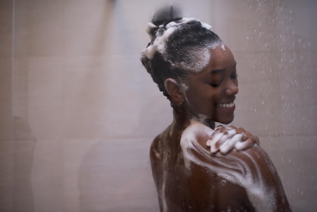 Frau in der Dusche, schöne schwarze junge Frau, die unter erfrischendem Wasser duscht, gesunder Lebensstil, Zeit im Luxus-Spa-Resort genießen