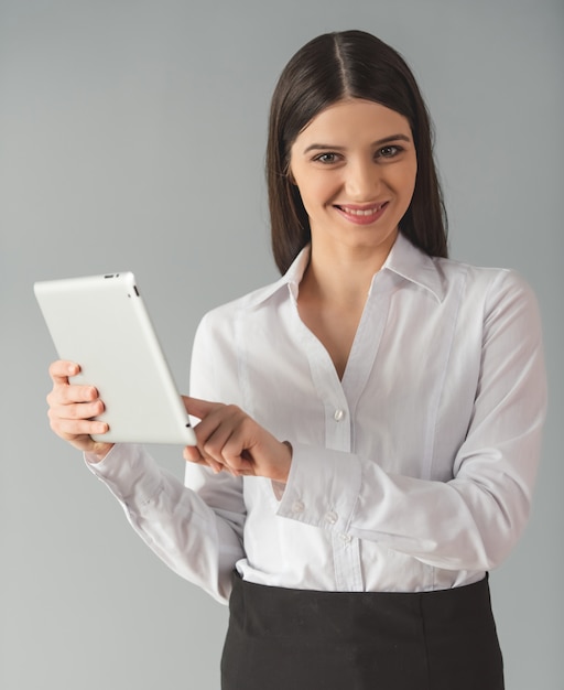 Frau in der formalen Kleidung benutzt eine digitale Tablette