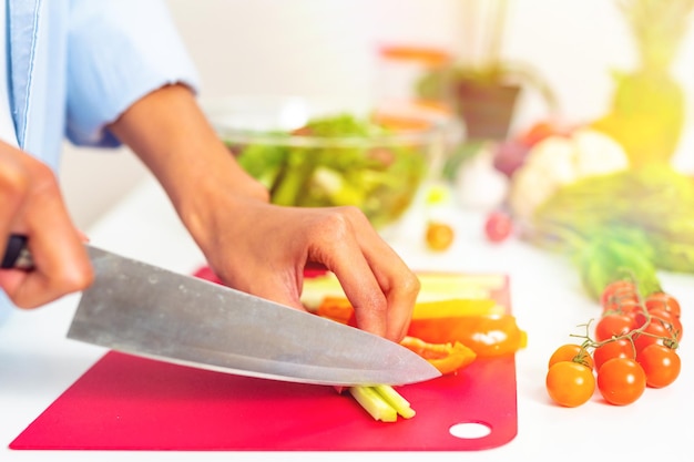 Frau in der heimischen Küche bereitet einen echten Salat mit frischem Gemüse zu