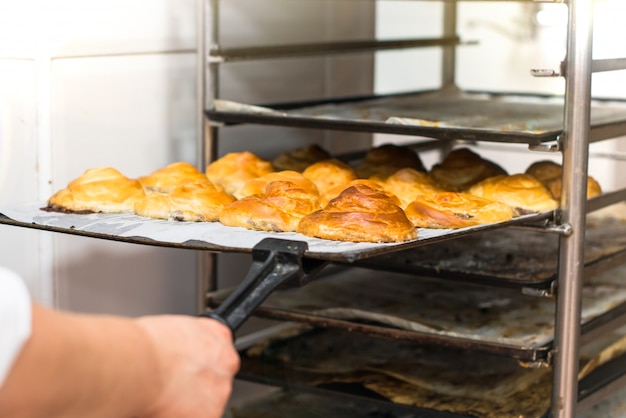 Frau in der Küche einer Bäckerei, die Kuchen kocht