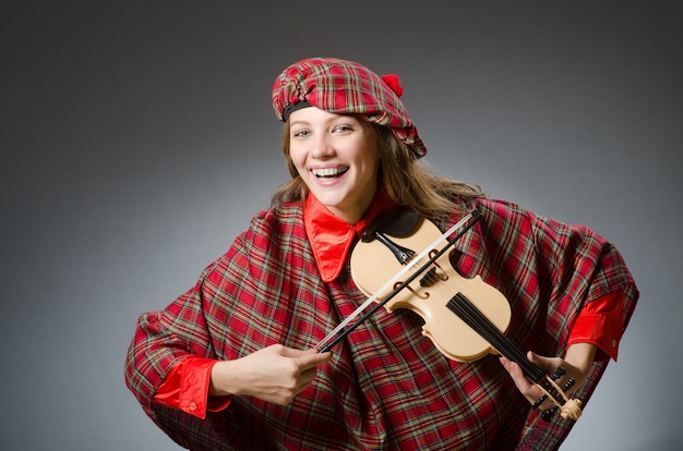 Frau in der schottischen kleidung im musikalischen konzept