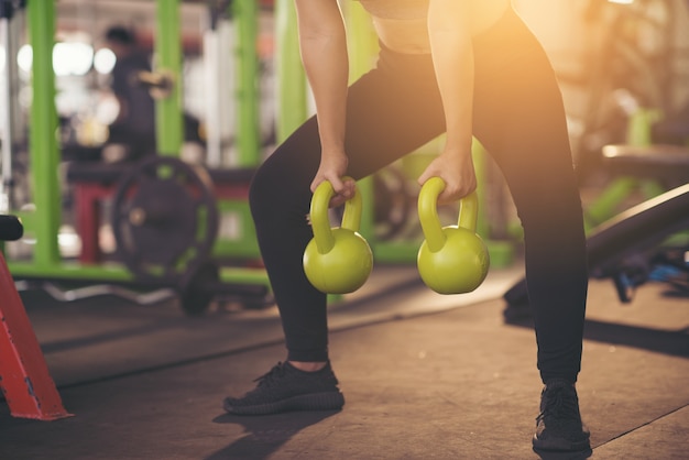 Frau in der Sportkleidung, die crossfit Training mit Kesselglocke tut. gesundes Konzept