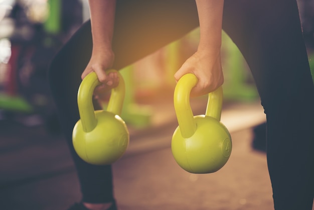 Frau in der Sportkleidung, die crossfit Training mit Kesselglocke tut. gesundes Konzept