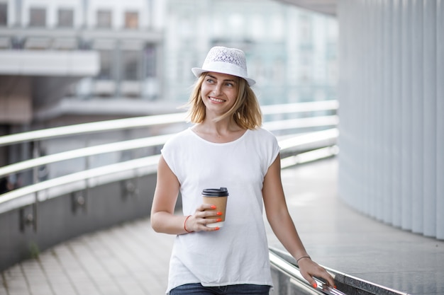 Frau in der Stadt mit Kaffee, Sommer und sonnigem Wetter.