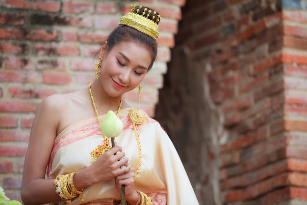 Frau in der traditionellen Kleidung falten Lotosblumenblumenblätter, die in der Buddhismusreligion benutzt werden.