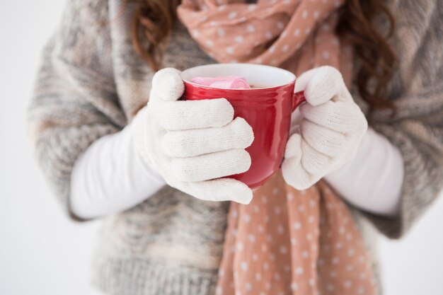 Frau in der Winterkleidung, die einen Becher anhält