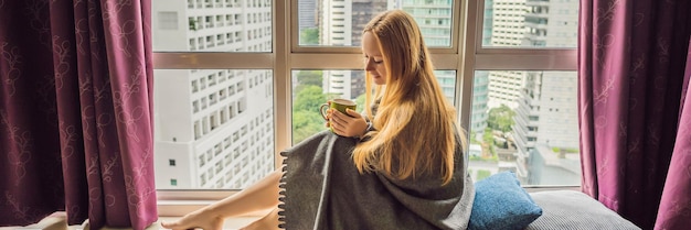 Frau in eine Decke gehüllt und mit Blick auf das große Stadtbanner-Langformat