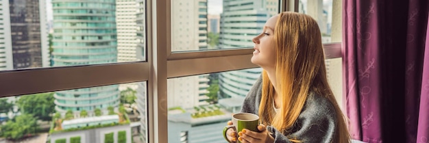 Frau in eine Decke gehüllt und mit Blick auf das große Stadtbanner-Langformat