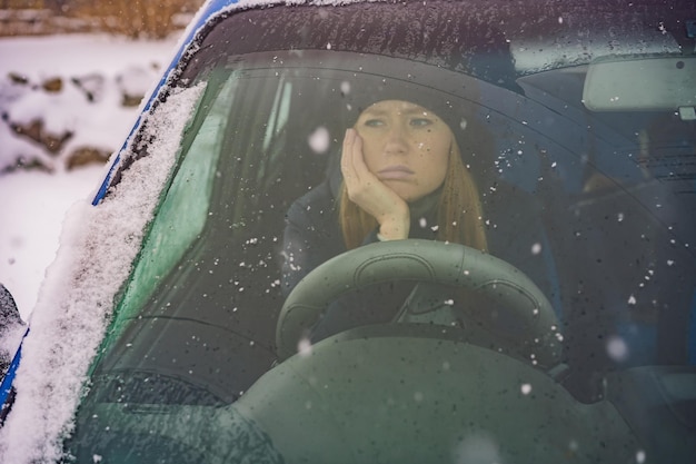 Foto frau in einem auto während einer schneefallprobleme auf der straße