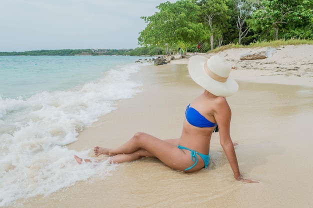 Foto frau in einem badeanzug posiert auf der playa blanca bar in cartagena in kolumbien mit bäumen und meer