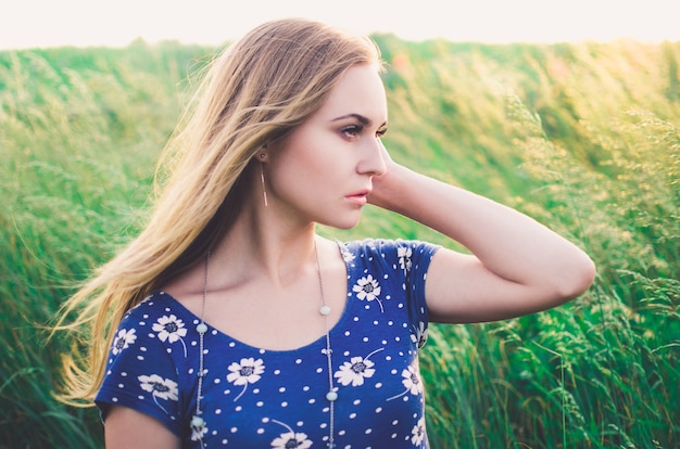 Frau in einem blauen Kleid mit Gänseblümchen