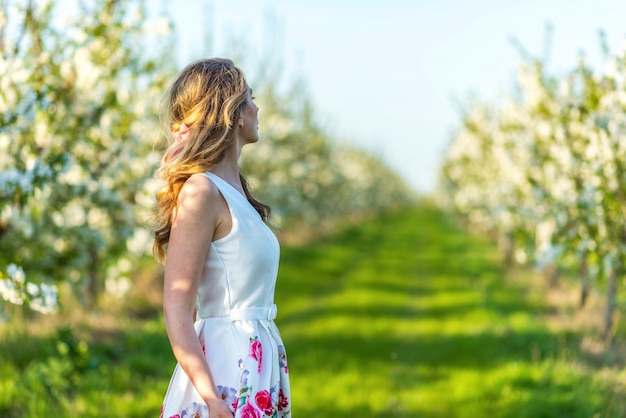 Frau in einem blühenden kirschgarten im frühjahr