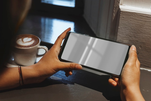 Frau in einem Café mit Handy