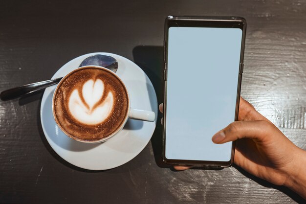 Frau in einem Café mit Handy