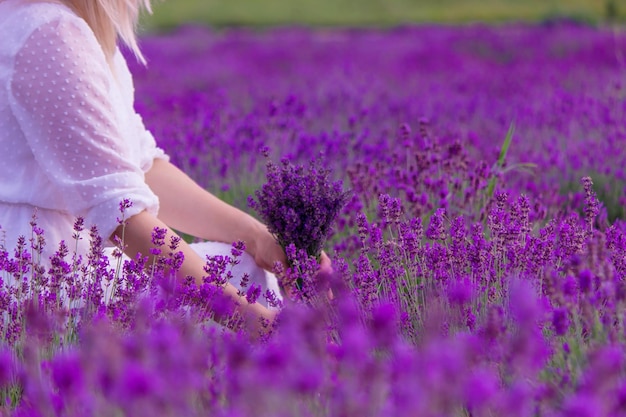 Frau in einem Feld von Lavendelblüten in einem weißen Kleid Ukraine