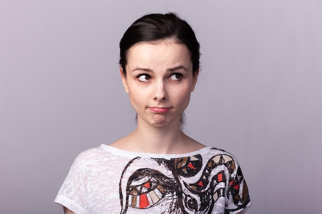 Frau in einem hellen T-Shirt Closeup Portrait auf grauem Hintergrund