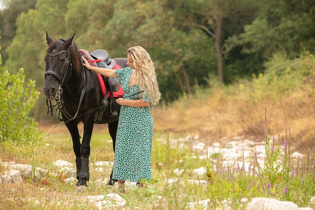 Frau in einem Kleid mit einem schwarzen Pferd