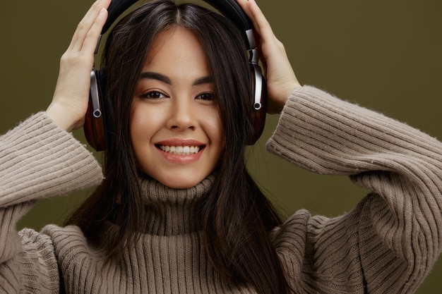Frau in einem Pullover, die Musik mit Kopfhörern hört, Spaß, isolierter Hintergrund