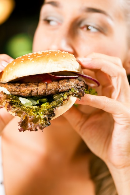 Frau in einem Restaurant Hamburger essend