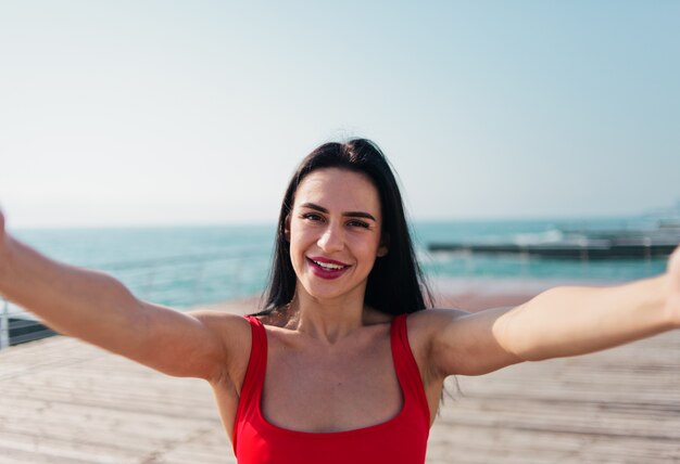 Frau in einem roten Badeanzug am Strand