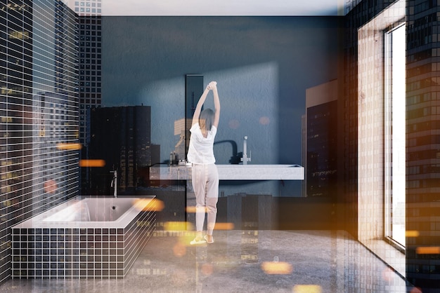 Frau in einem schwarzen Fliesenbad mit einem langen Waschbecken und einem Loftfenster. Ein Betonboden. Ein gemütliches Hauskonzept 3D-Rendering-Mock-up-Ton-Bild-Doppelbelichtung
