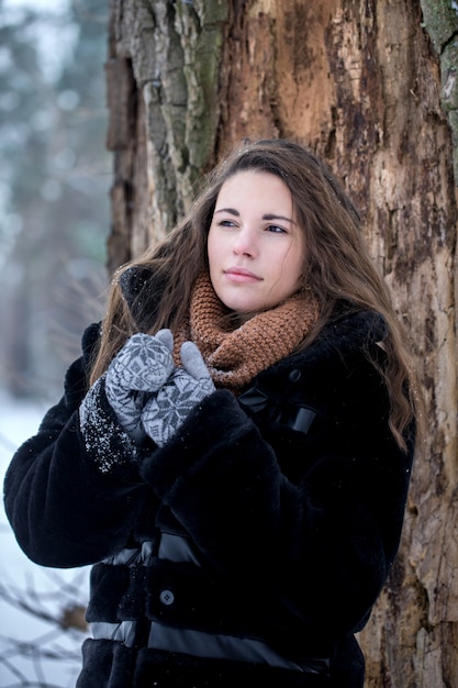 Frau in einem schwarzen Pelzmantel im Winter im Park