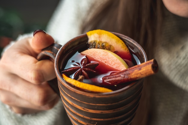 Frau in einem warmen Pullover trinkt aromatischen heißen Glühwein