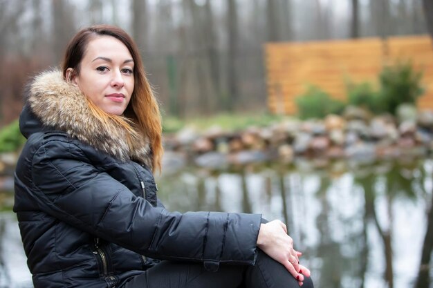 Frau in einer Jacke auf einem Hintergrund der Natur