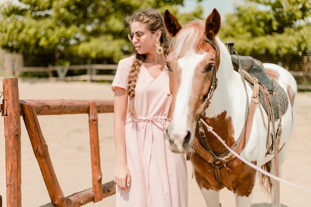 Frau in einer Landschaft mit einem Pferd von der Ranch