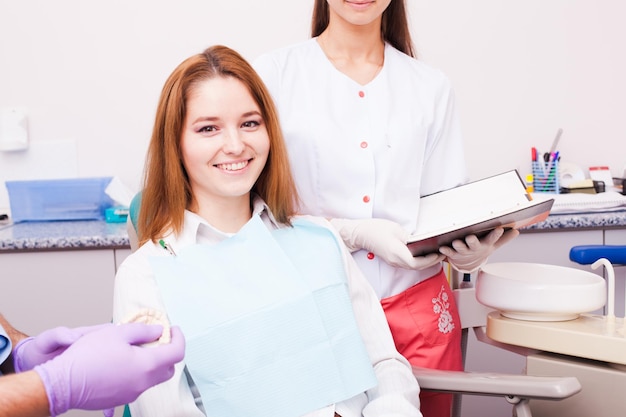 Frau in einer Zahnarztpraxis, die die Farbe ihrer Furniere auswählt