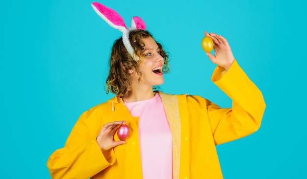 Frau in Hasenohren mit farbigen Eiern fröhliches Osterhasenmädchen Eiersuche Frühlingsferien