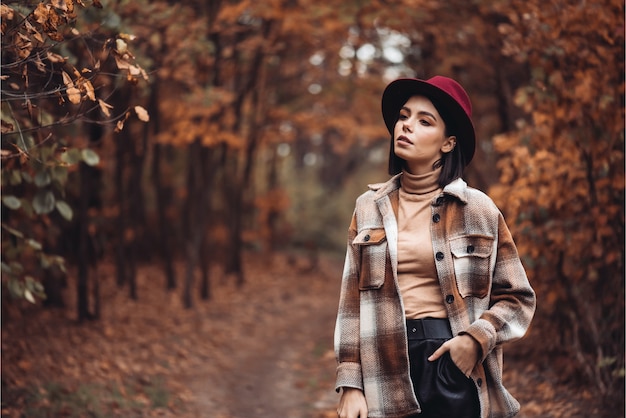 Frau in Hut und Mantel im Wald