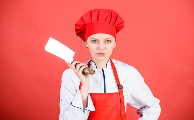 Frau in Kochmütze und Schürze professioneller Koch in der Küche Küche Metzger geschnittenes Fleisch glückliche Frau, die gesundes Essen nach Rezept kocht Hausfrau mit Kochmesser Zeit für das Abendessen