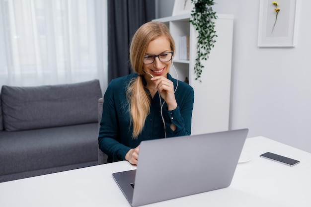 Frau in Kopfhörern mit Laptop