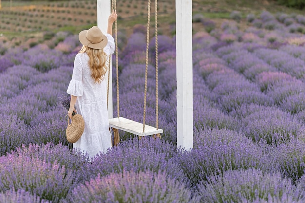 Frau in Lavendelfeld bei Sonnenuntergang in lila Kleid Frankreich Provence