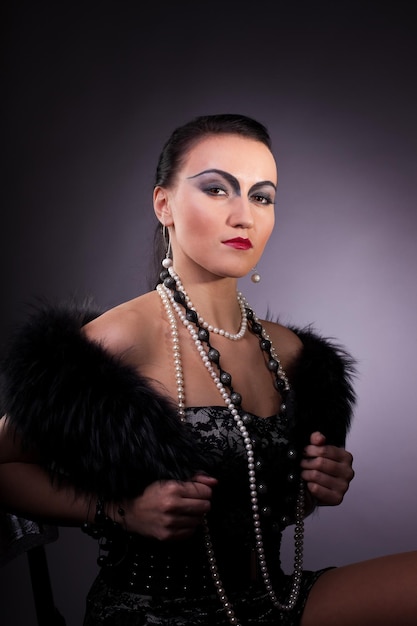 Frau in Pelzboa mit Perlen im Retro-Stil