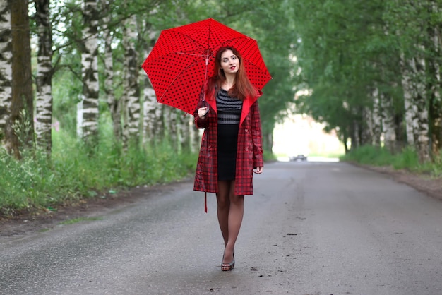 Frau in Regenmantel und Regenschirm