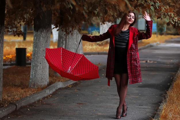 Frau in Regenmantel und Regenschirm