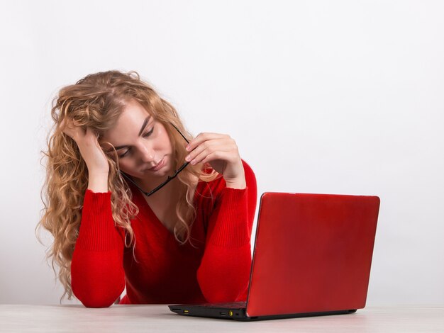 Foto frau in rot, die am computer auf weiß arbeitet.