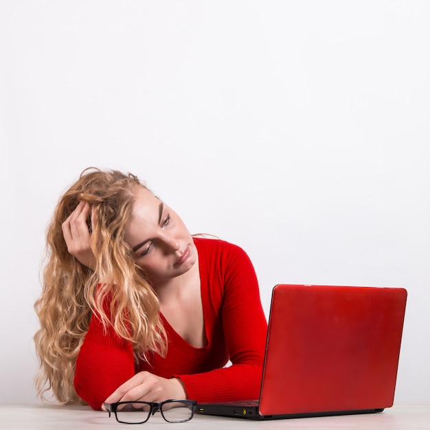 Frau in Rot, die am Computer auf Weiß arbeitet.