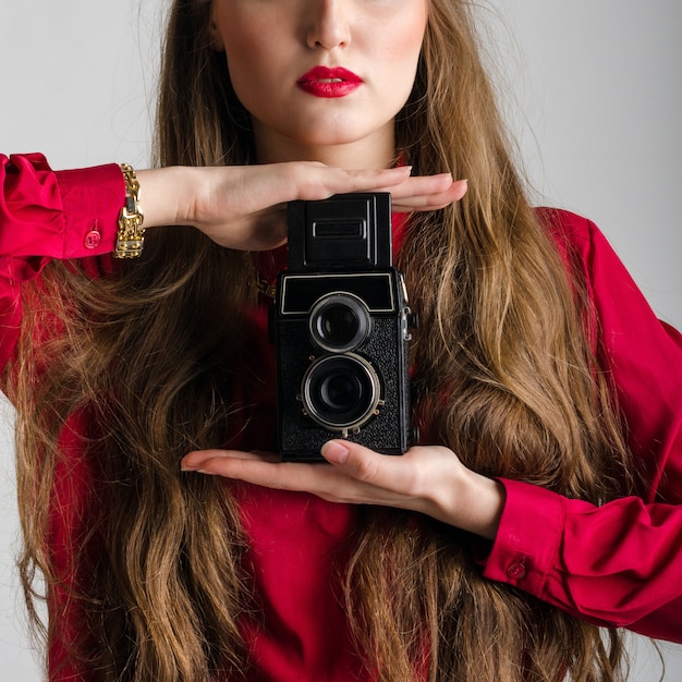 Frau in Rot mit seltener alter Fotokamera