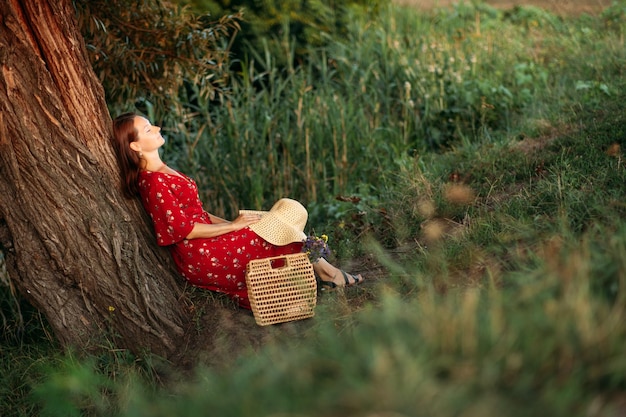 Frau in rotem Kleid genießt die Natur Naturtherapie Ökotherapie-Praxis des Aufenthalts in der Natur zur Förderung des Wachstums und zur Heilung der psychischen Gesundheit Die Verbindung mit der Natur fördert die psychische Gesundheit