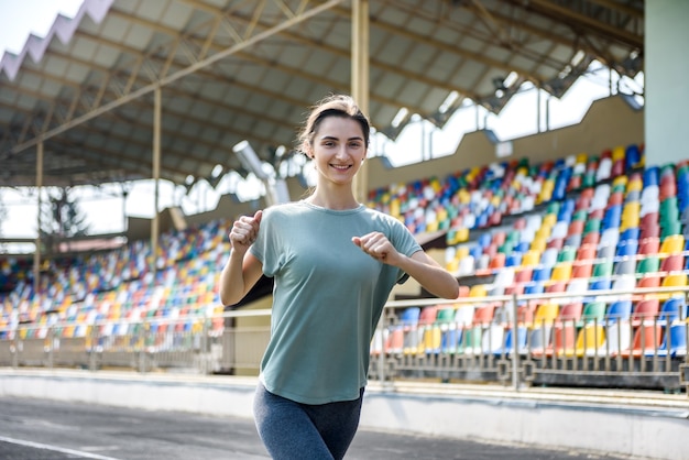 Frau in Sportkleidung beim Morgenlauf im Stadion