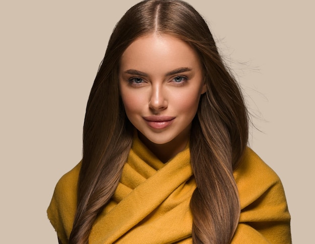 Frau in Strickkleidung gelbes Herbstwinter-Stil langes Haar. Hintergrundfarbe braun