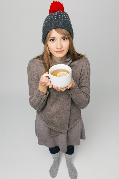 Foto frau in strickmütze mit einer tasse tee