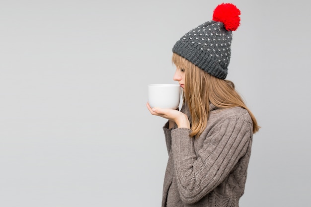 Foto frau in strickmütze mit einer tasse tee